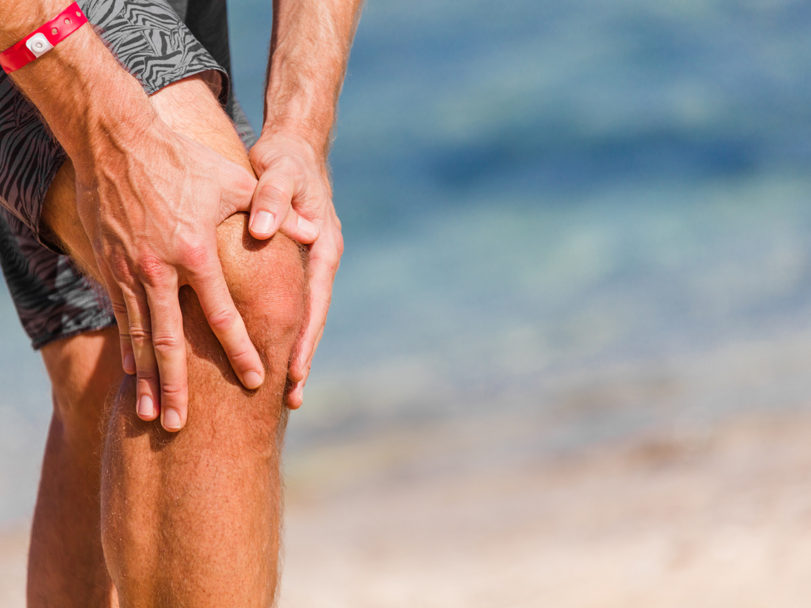 man on beach with arthritis in knee